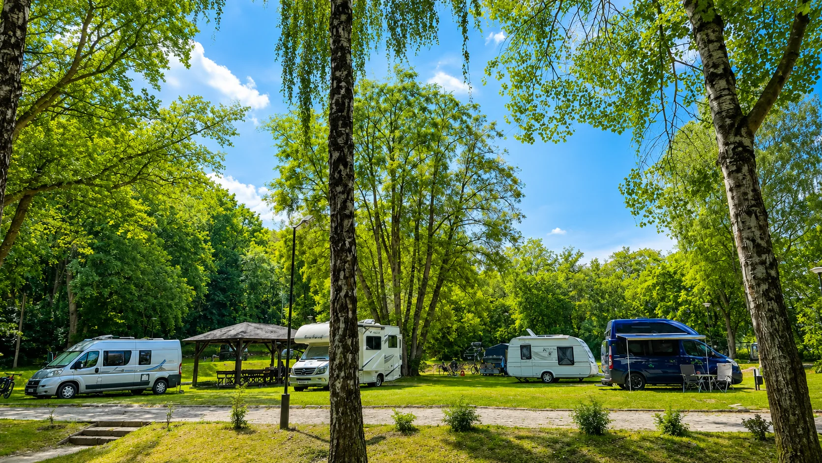 Kampery i przyczepy w zielonym parku na Campingu Spichlerz