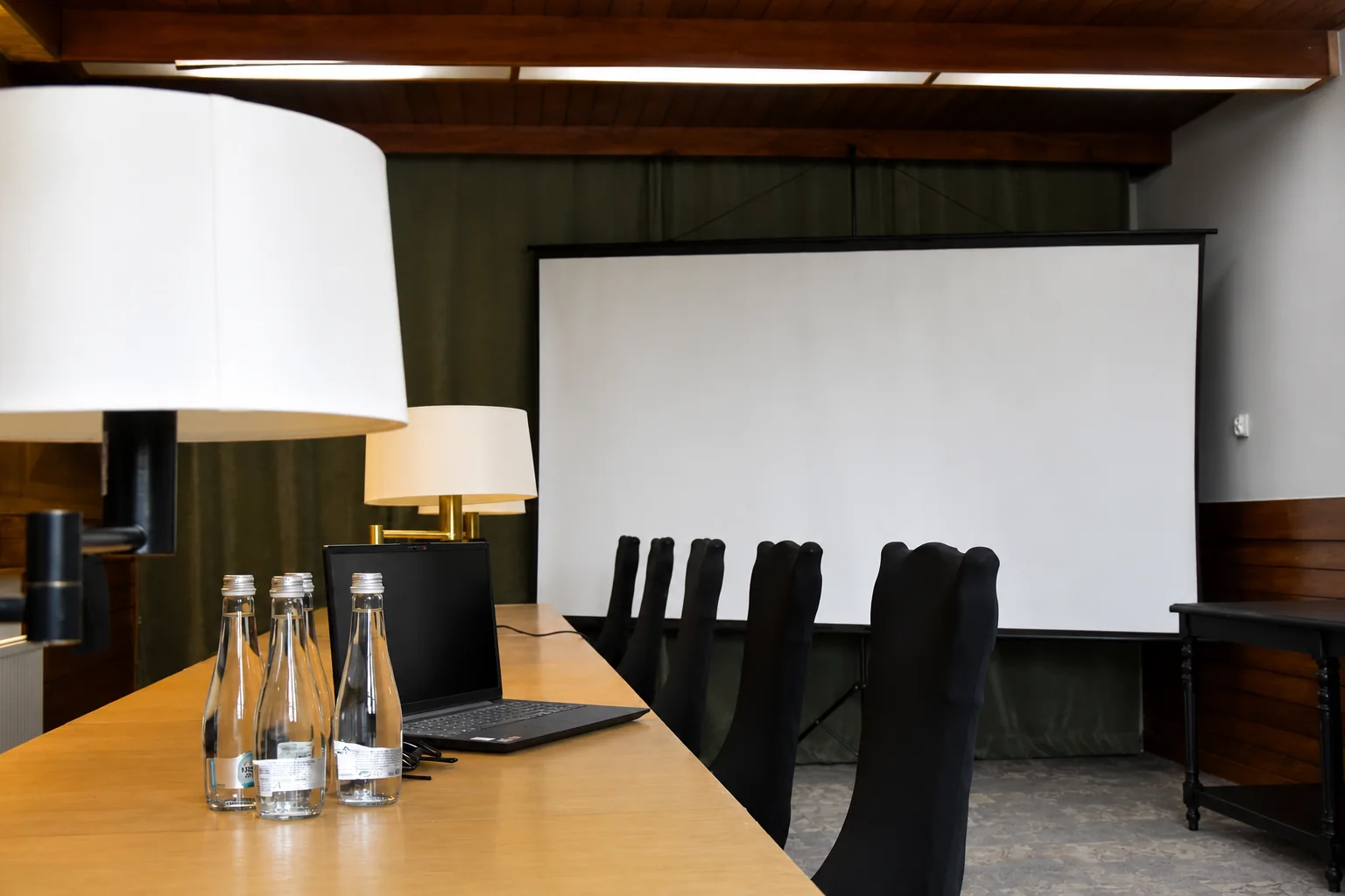 Sala w Willi Murka ze stołem konferencyjnym i ekranem projekcyjnym
